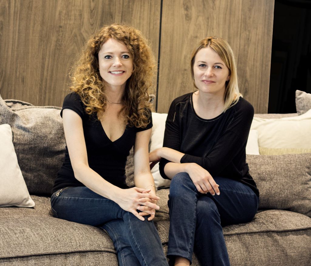 Dwie kobiety siedzące na sofie. Po lewej stronie Anna Wojtas, po prawej Monika Mach.